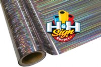 The image shows a close-up view of a rainbow textile foil. The foil features a shiny, metallic surface with holographic parallel lines on top of the silver.